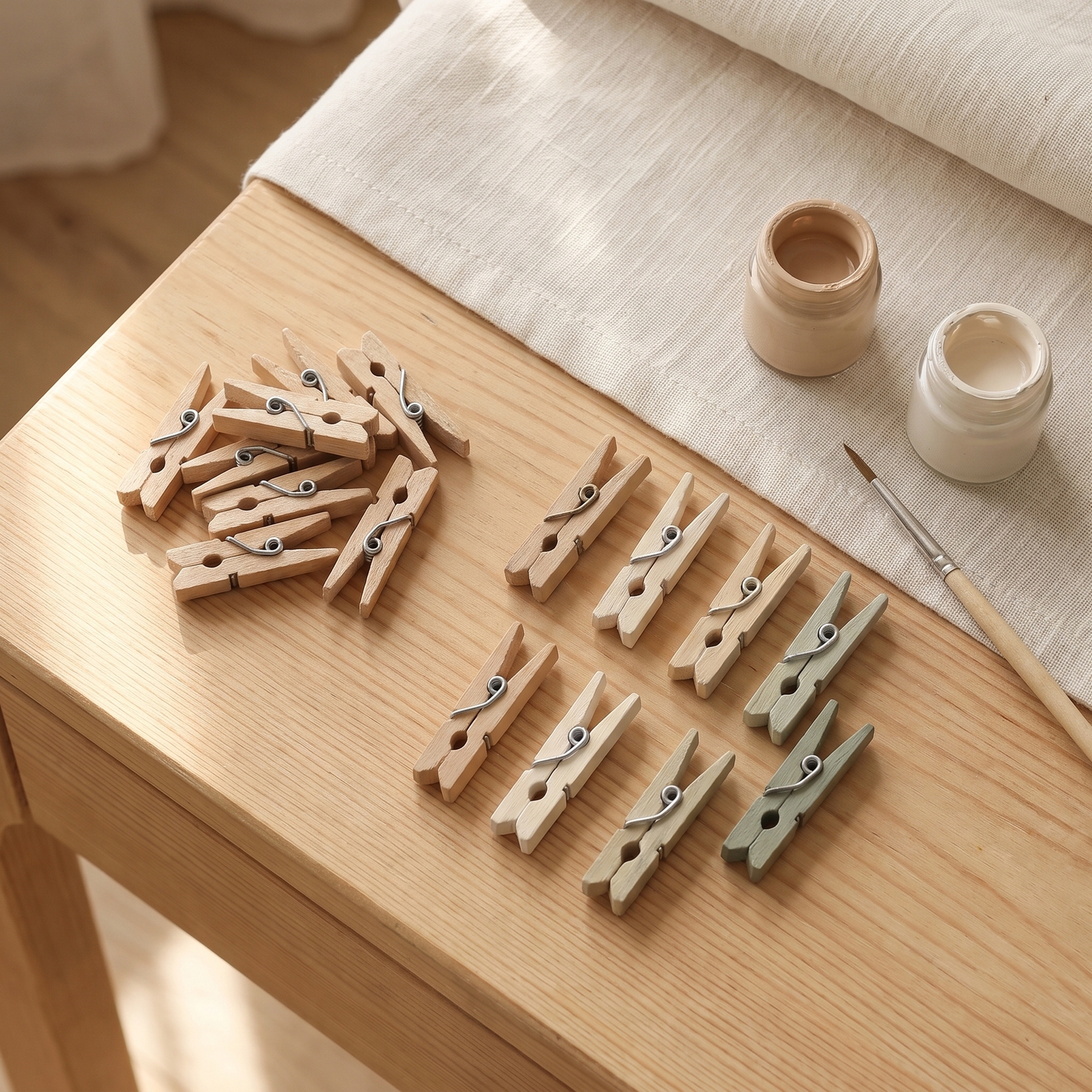 Naturbelassene und bemalte Mini-Holzklammern aus Birke mit Pinsel und Farbtöpfchen