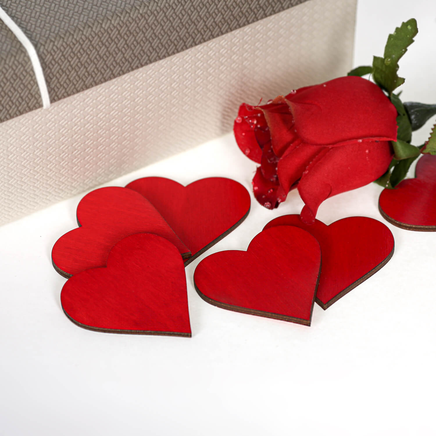 Gruppe roter Holzherzen mit roter Rose und Geschenkbox