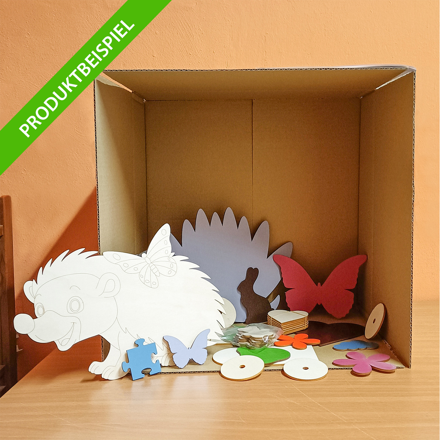geöffnete, mittlere Ü-Box M+ mit Produktbeispielen aus Sperrholz naturbelassen und farbig lackiert
